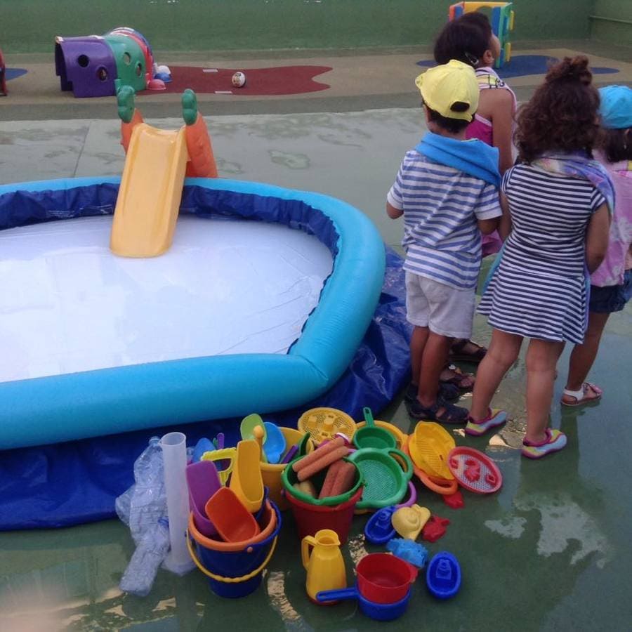 Nins i Nines niños junto a piscina inflable